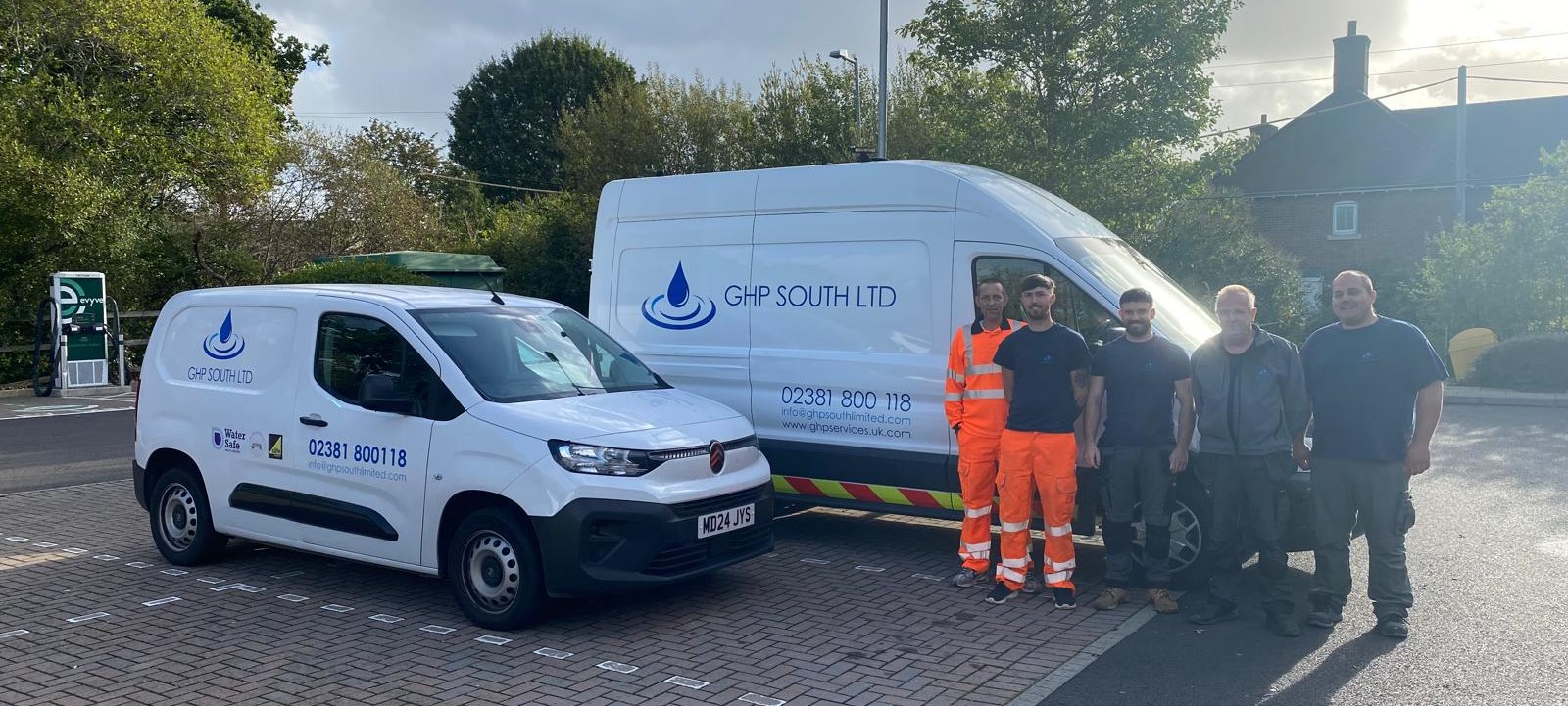The GHP South LTD team standing beside their two liveried company vans
