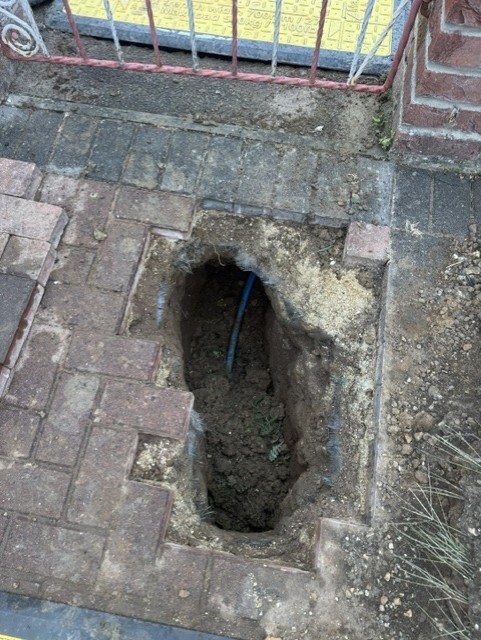 Excavation in block paving with new blue pipe laid